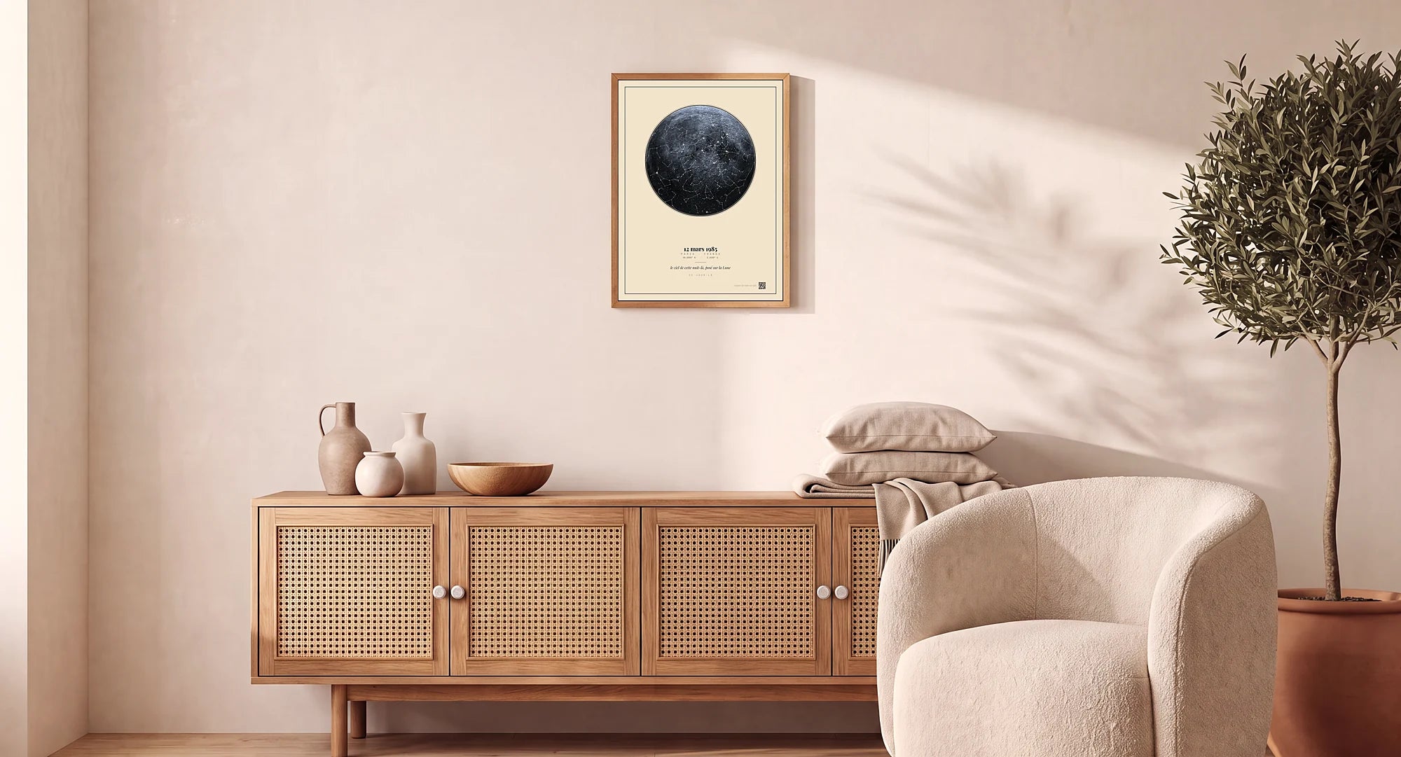 Une affiche Ce Jour-Là — la Lune sur fond crème — encadrée dans un cadre en bois, posée au-dessus d'un buffet en cannage dans un salon japandi lumineux, à sa vraie échelle